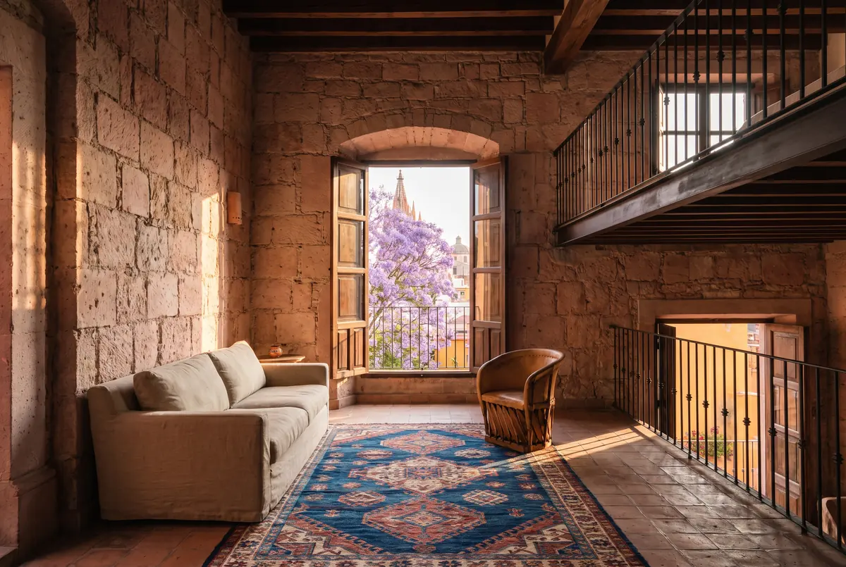 Sala de doble altura con muros de cantera